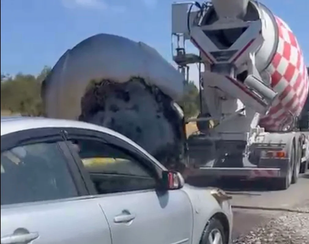Ayvalık’ta seyir halinde alevler içinde kalan otomobilin imdadına beton mikseri yetişti
